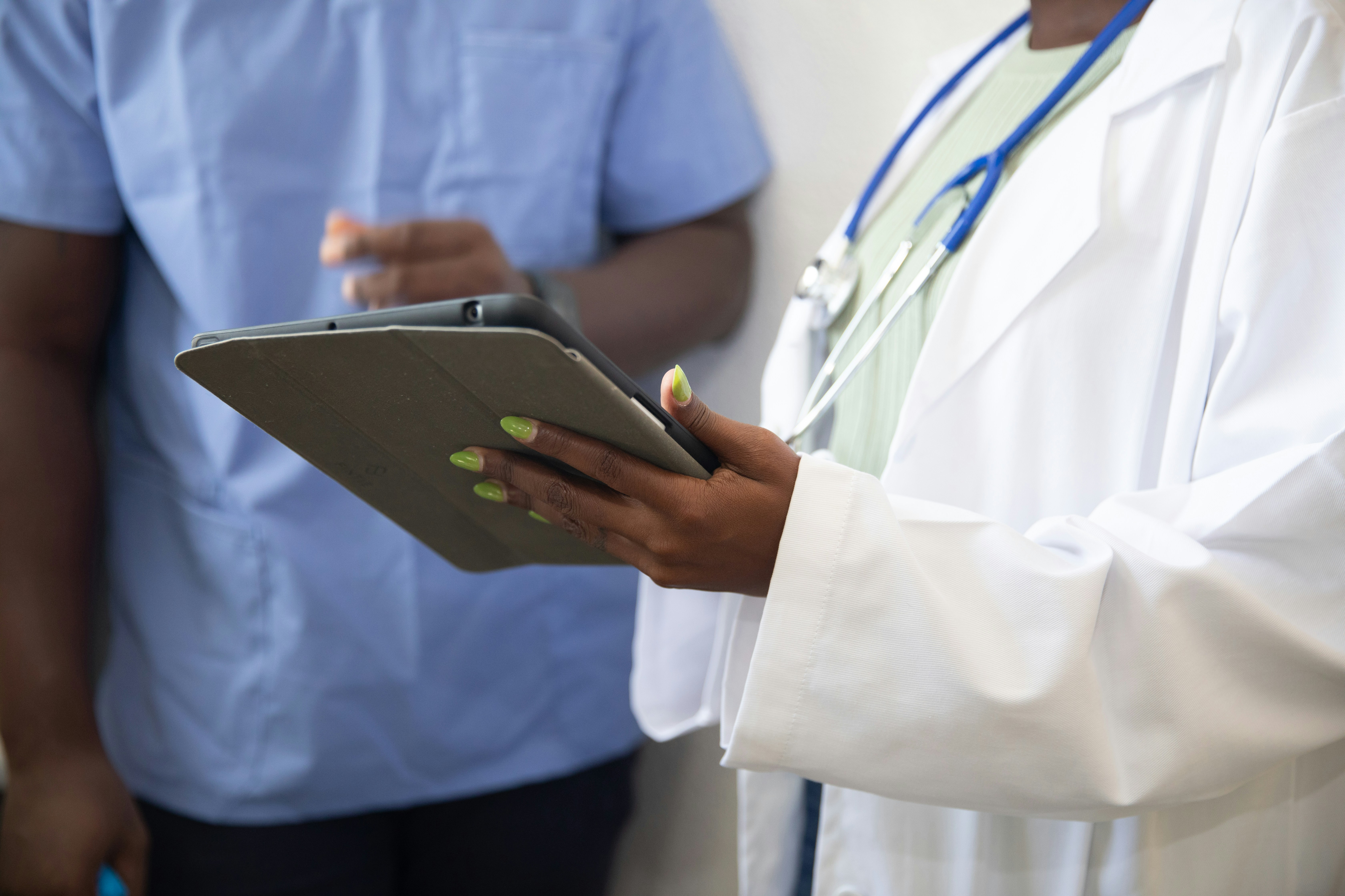 Two healthcare professionals reviewing study materials on a tablet
