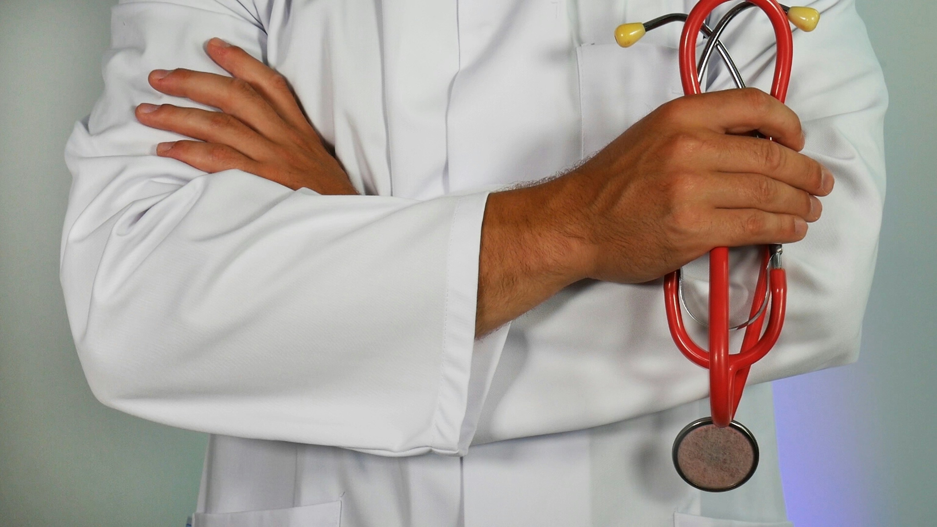 Healthcare professional working at a laptop with a stethoscope nearby
